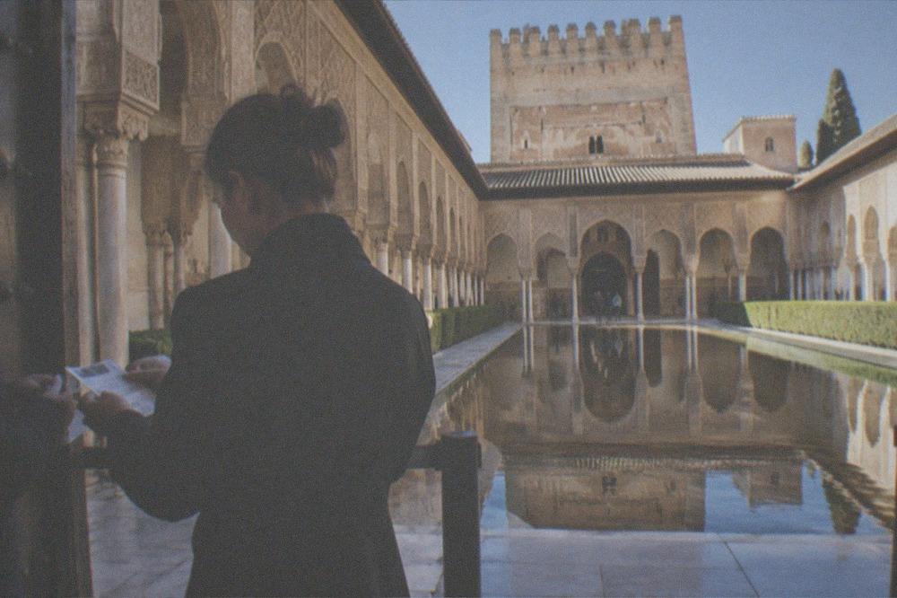 A staff member checking printed tickets at the gate to the Nasrid Palaces