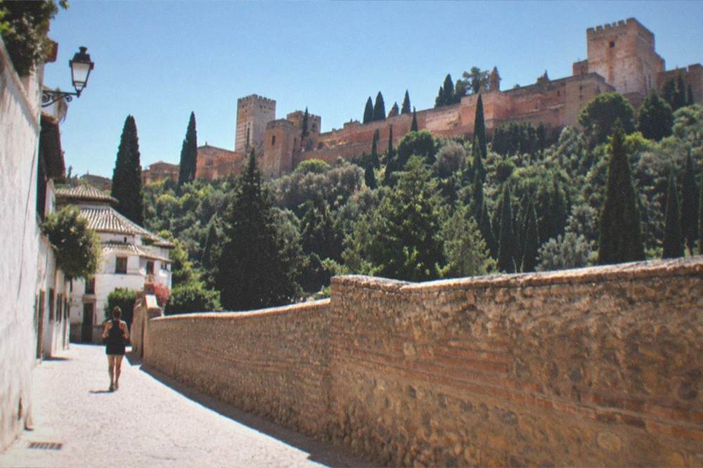 A Granada Card and Alhambra ticket held in hand at a monument entrance