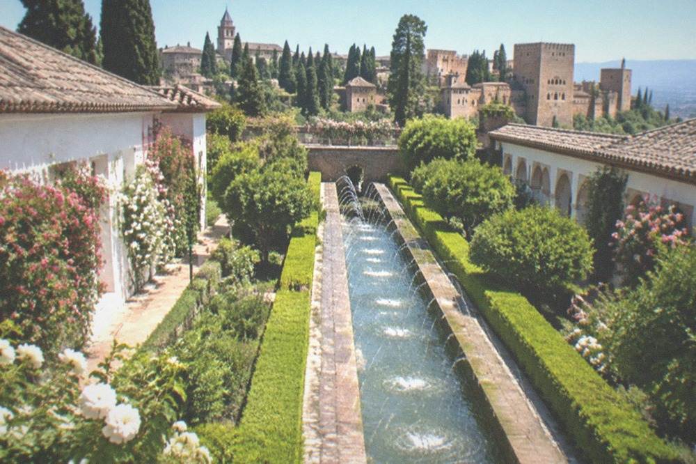 The long water channel of the Generalife with clipped hedges and the Alhambra beyond