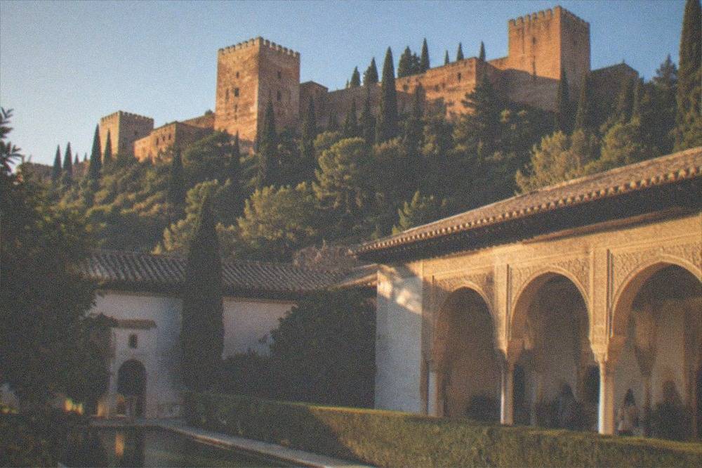 The courtyard of the Parador de Granada with Moorish arches and manicured hedges inside the Alhambra grounds