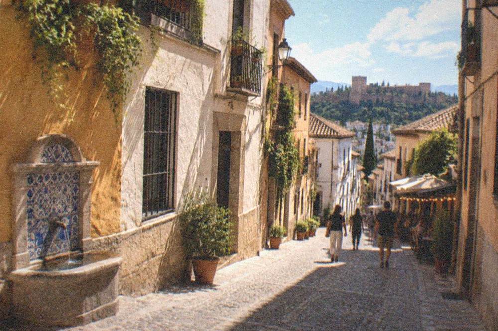 An evening street in the Realejo with lit tapas bars and people walking between them