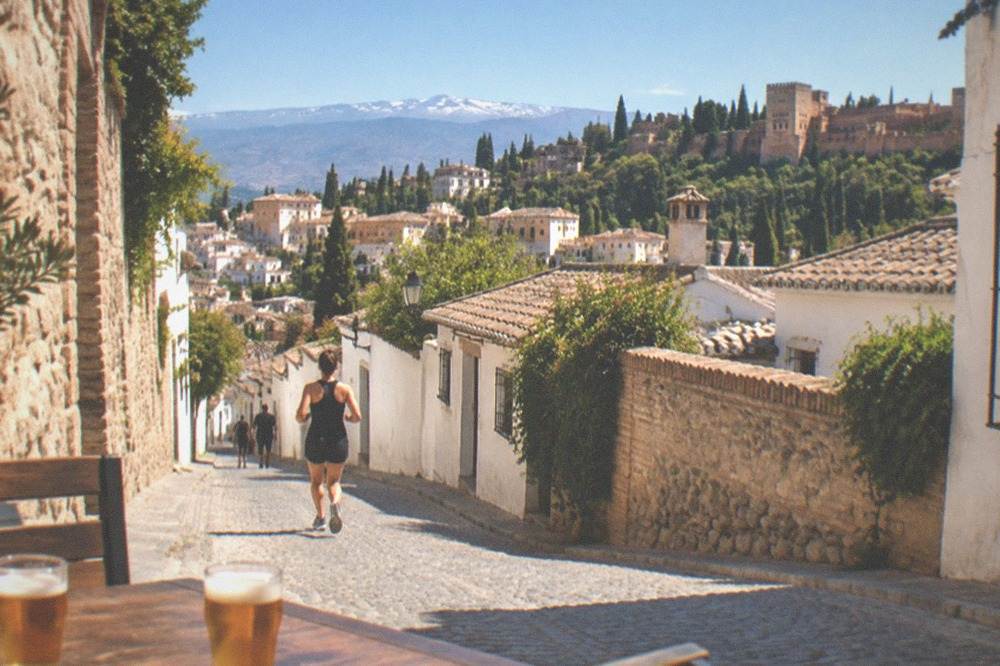 Two small glasses of beer beside a chalkboard listing the day's tapas in a Granada bar