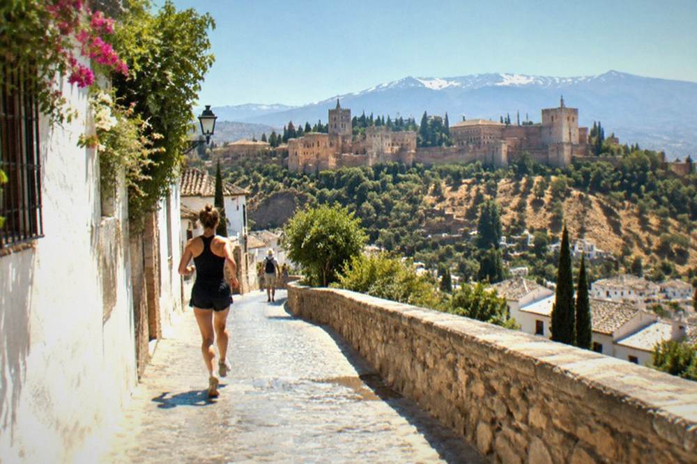 A road winding through dry hills near Granada under a hot summer sky