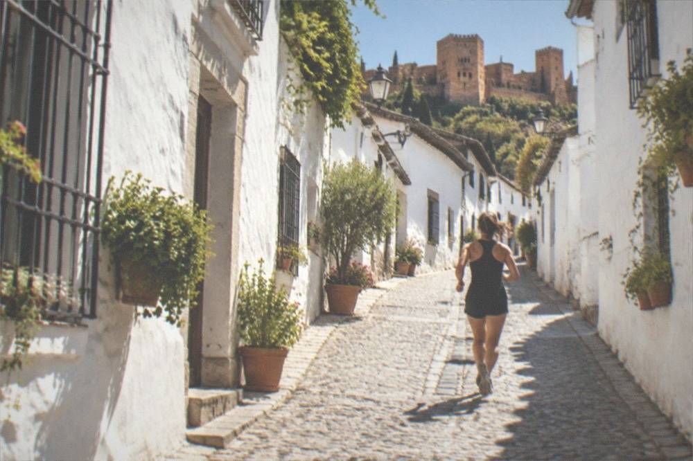 A narrow cobbled street in the Albaicin with whitewashed houses and potted plants