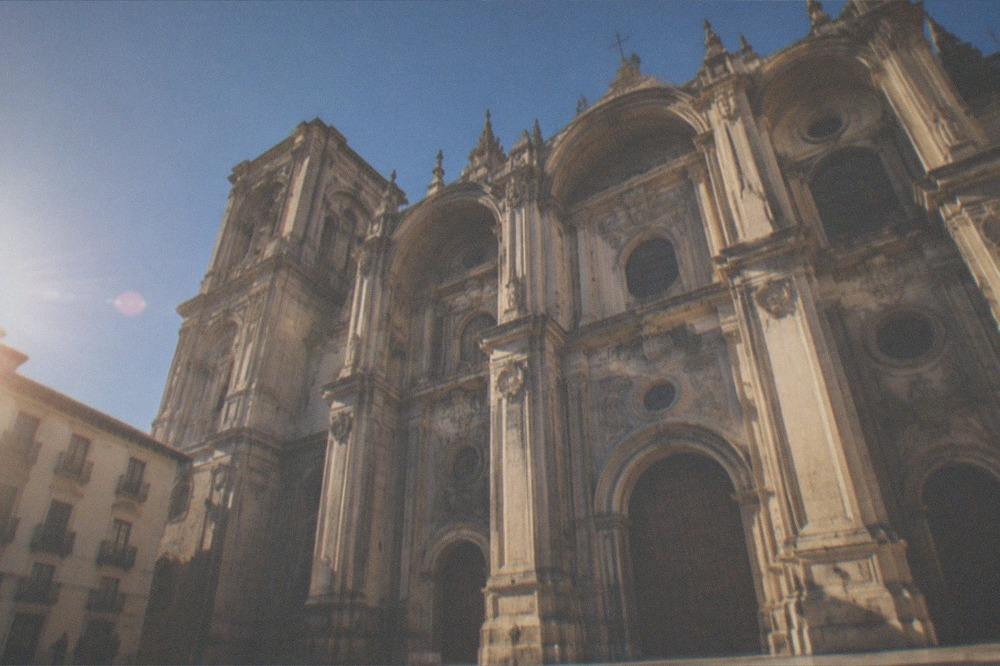 The ornate gothic interior of the Granada Cathedral with tall columns and stained glass