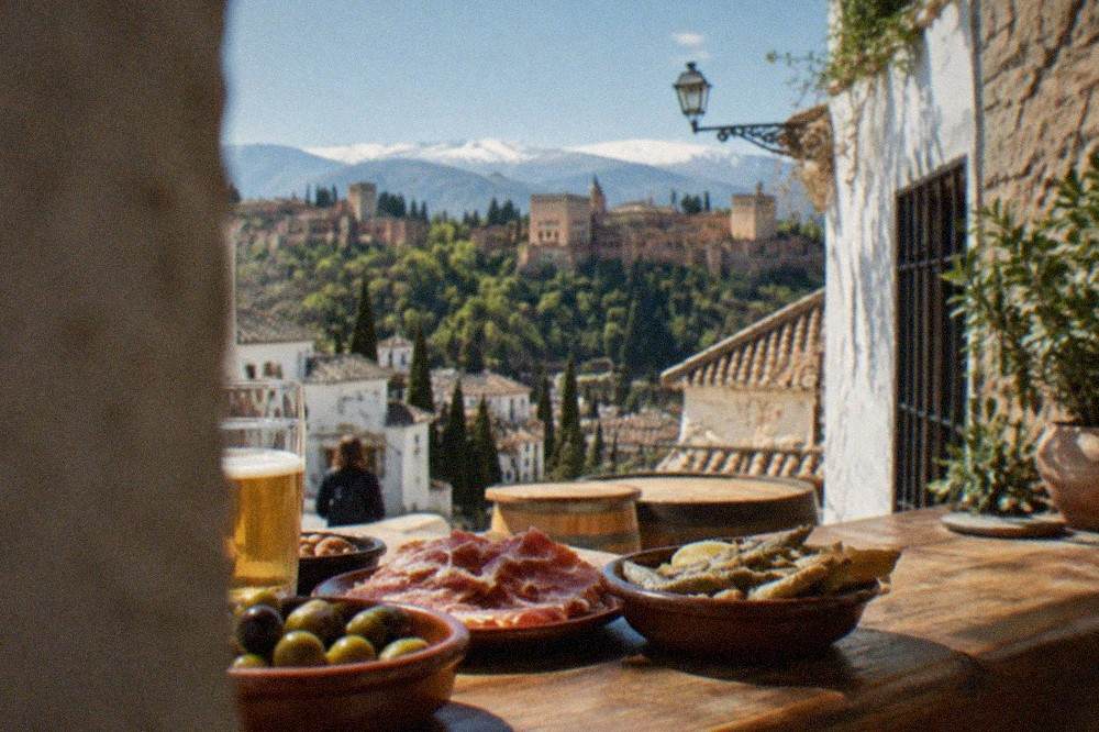 Small ceramic dishes of olives, ham and fried fish on a wooden tapas bar counter