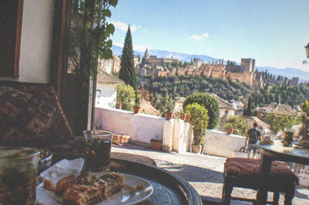 A tea house interior on a Granada street with pastries and glasses of mint tea on low tables