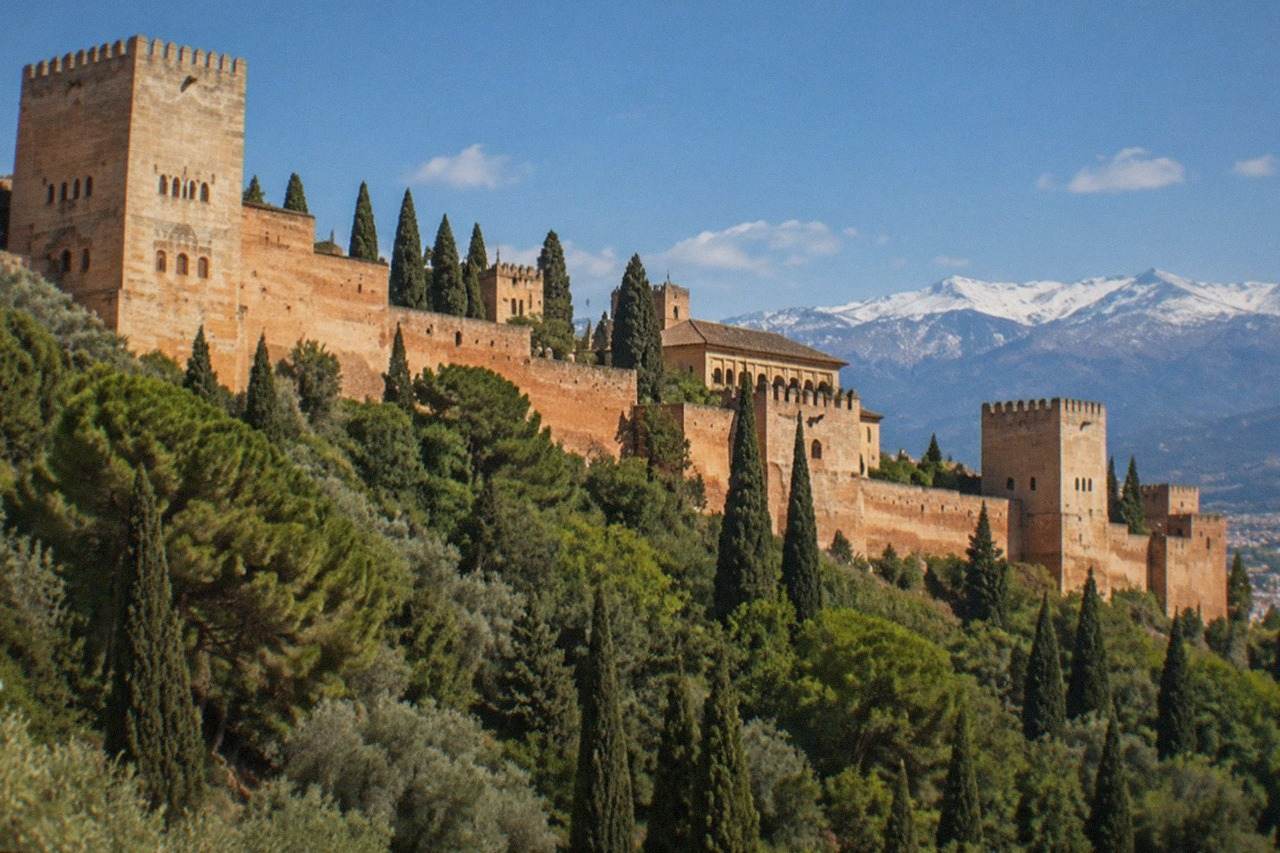 The Alhambra palace complex on its hill above Granada with the Sierra Nevada in the background