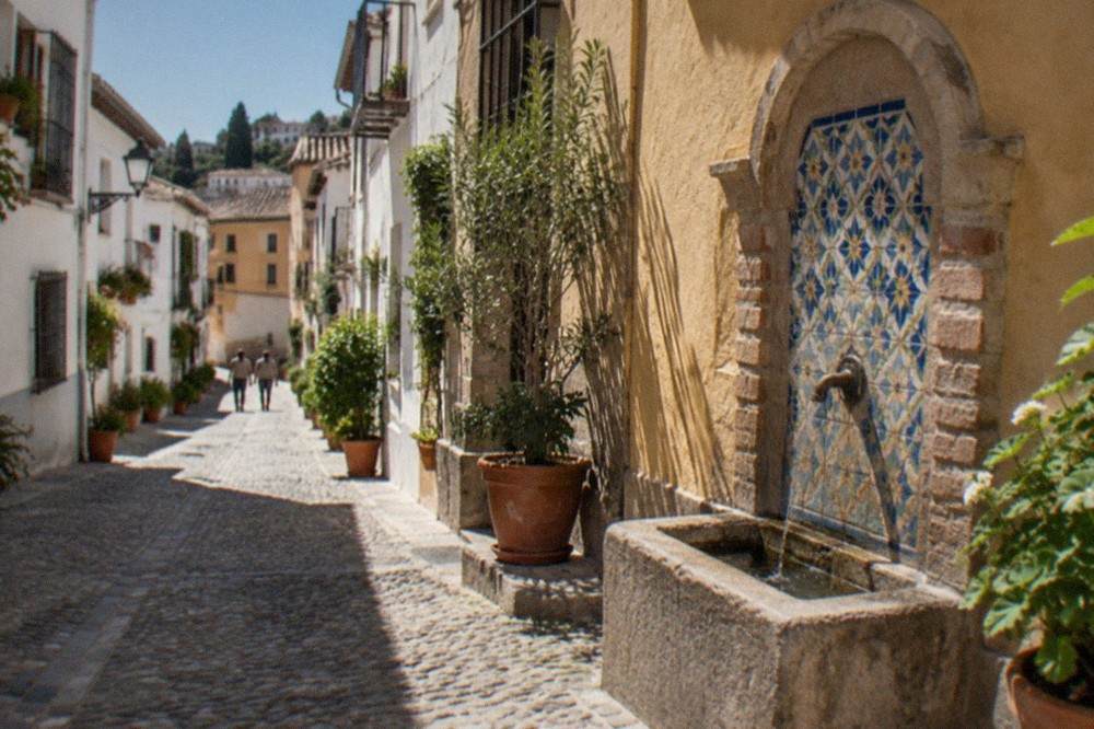 A quiet cobbled street in the Realejo district with whitewashed houses and potted plants