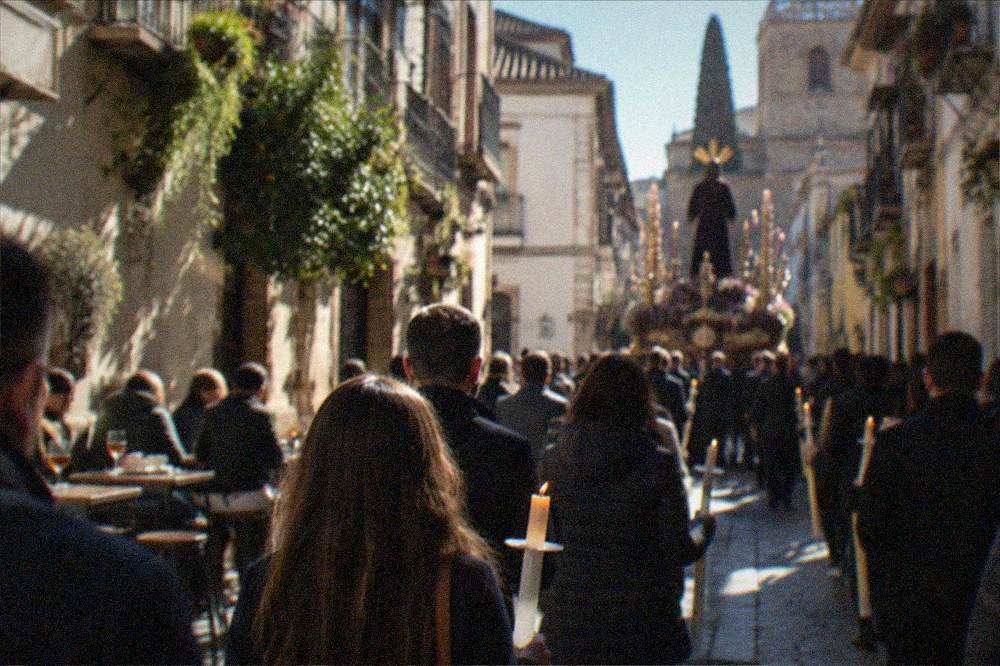 An evening procession crowd in a Spanish city street with candles