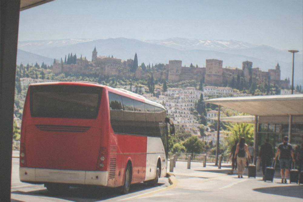 Red and white Alsa airport bus parked at Granada airport terminal