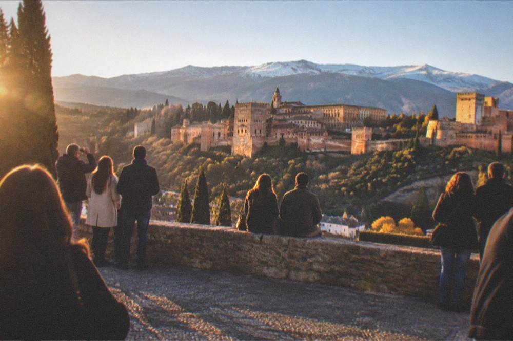Crowd gathered at Mirador de San Nicolas watching sunset light on the Alhambra