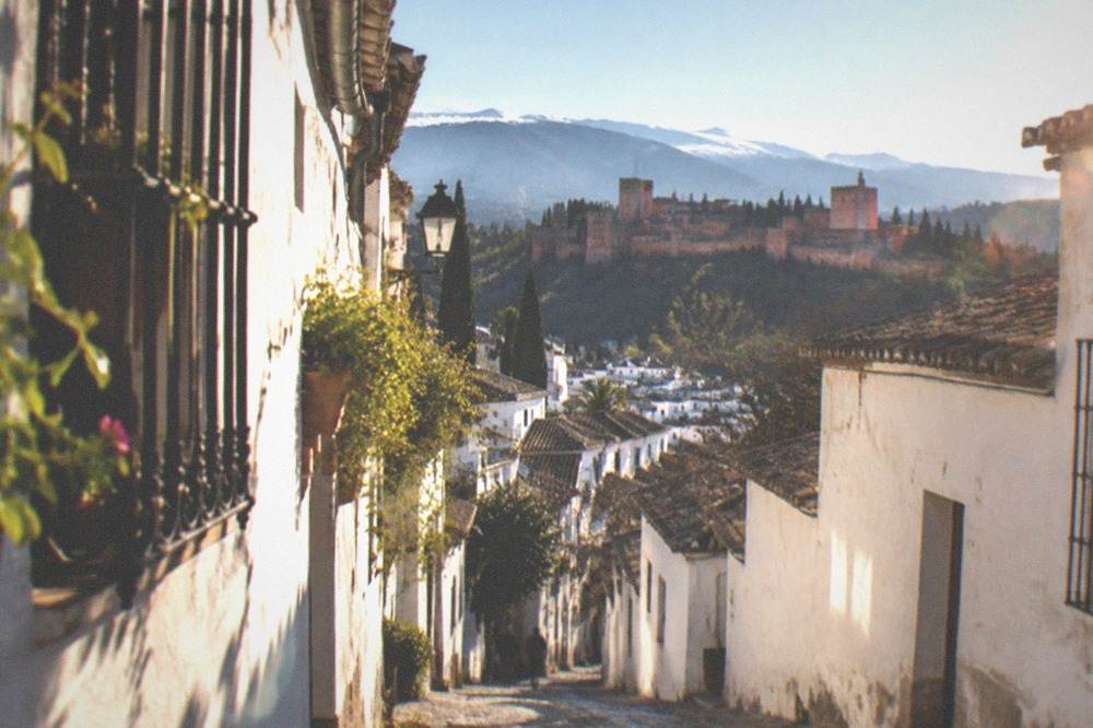 Whitewashed hillside houses in the Albaicin quarter with the Sierra Nevada in the background