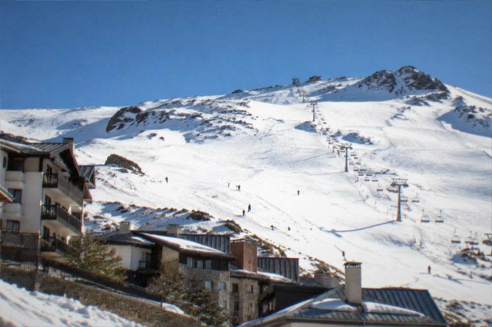 The Sierra Nevada mountains with snow peaks rising behind the rooftops of Granada