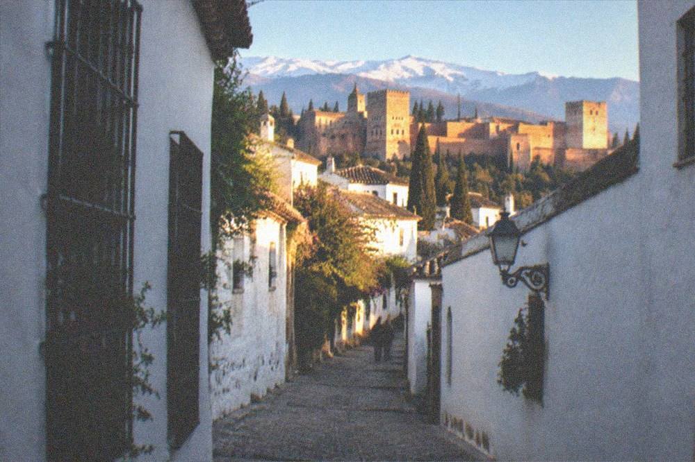 Golden evening light over the whitewashed houses of the Albaicin district with the Sierra Nevada peaks behind
