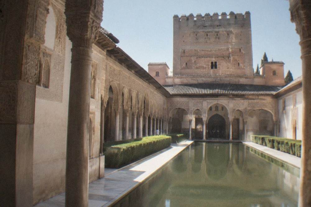 Carved stucco walls and arched windows inside the Nasrid Palaces of the Alhambra