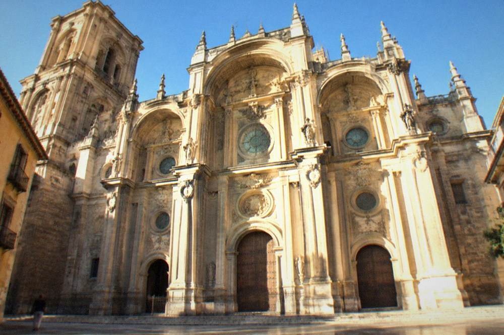 The ornate baroque facade of Granada Cathedral in late afternoon light