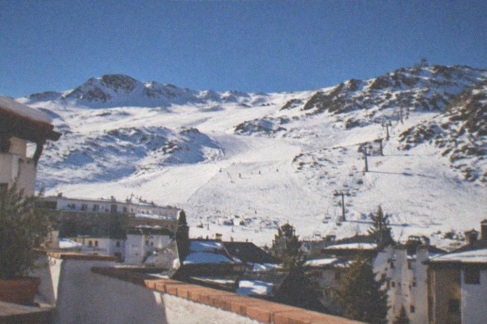 Snow-covered peaks of the Sierra Nevada seen from a rooftop terrace in Granada