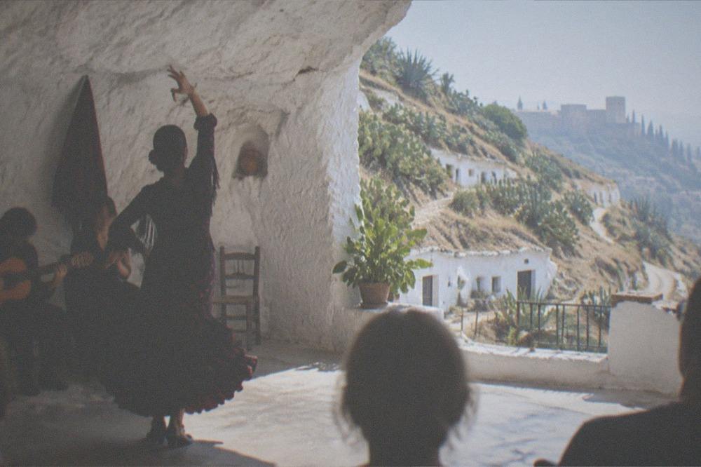 A flamenco dancer performing inside a whitewashed cave venue in Sacromonte