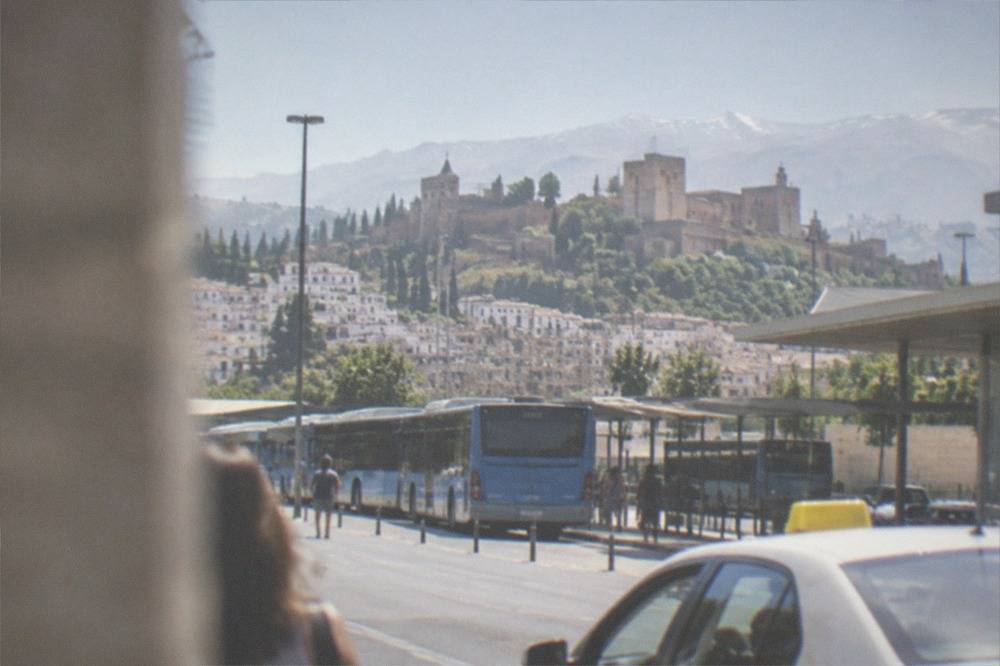 A taxi and city buses waiting outside a Spanish railway station