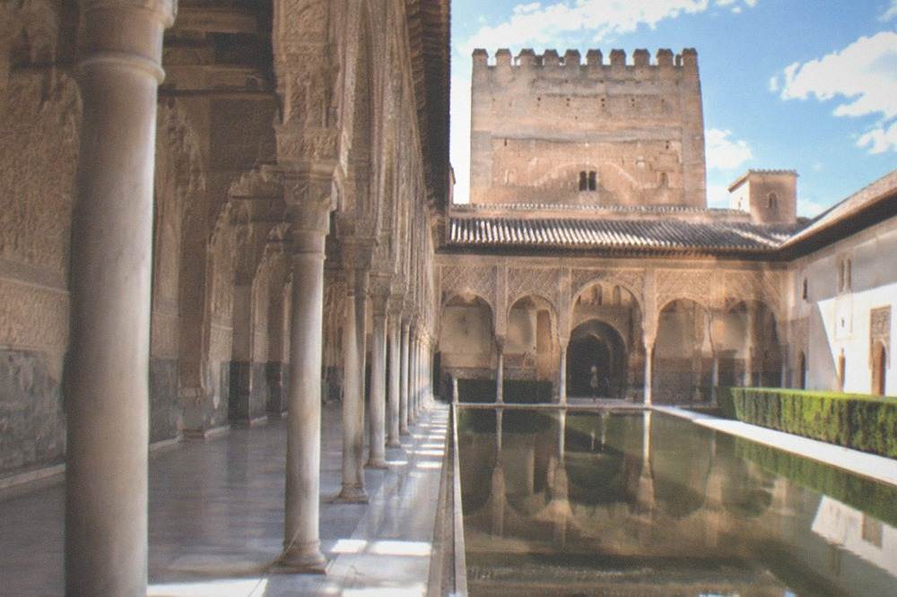 The ornate arches and carved stucco walls of a Nasrid palace courtyard