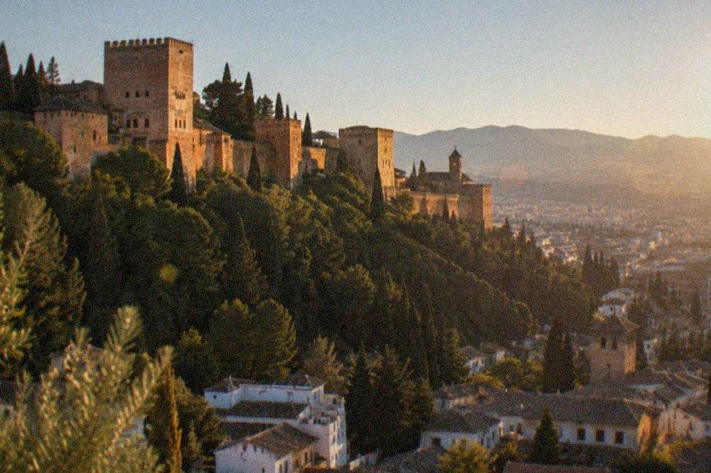 An evening view of the Alhambra walls with the city of Granada lit below