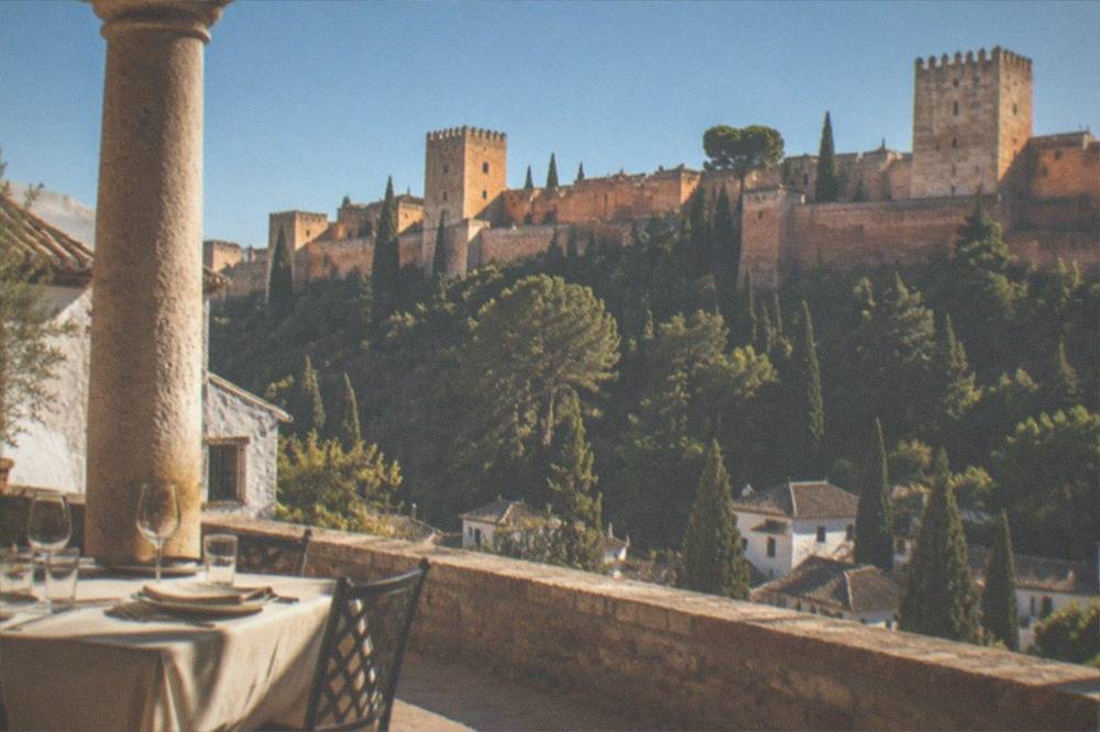 A set restaurant table beside stone columns in a historic courtyard