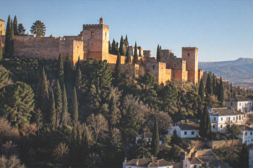 White hillside houses with cave doorways above the city at sunset