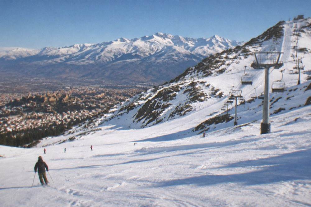 Snow-capped Sierra Nevada mountains rising behind the city rooftops of Granada in winter