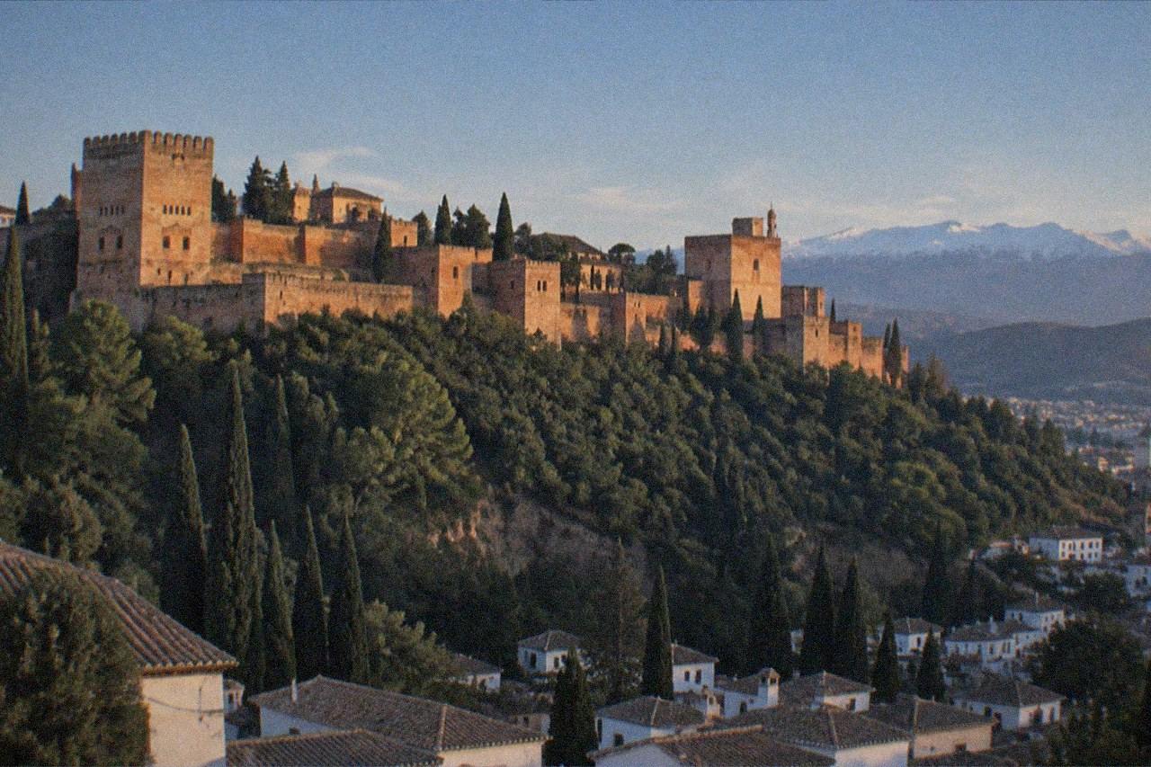 The towers of the Alhambra rising above Granada with the Sierra Nevada in the distance