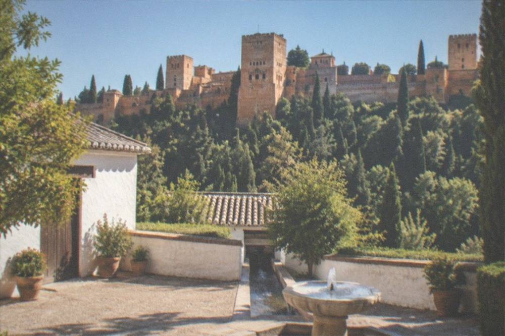 A quiet courtyard with a narrow water channel feeding a stone fountain