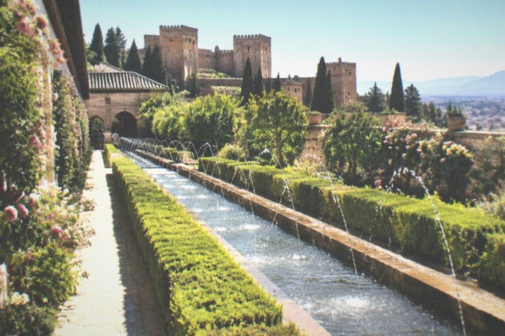 The Generalife gardens with clipped hedges, water channels and the city below