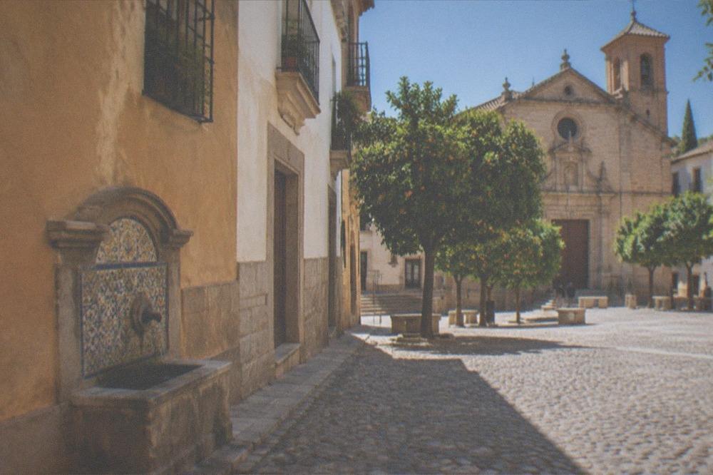 A quiet square in the Realejo with orange trees and a church facade