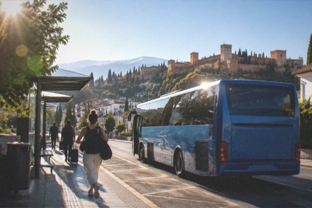 An Alsa airport bus parked at a stop outside Granada airport terminal