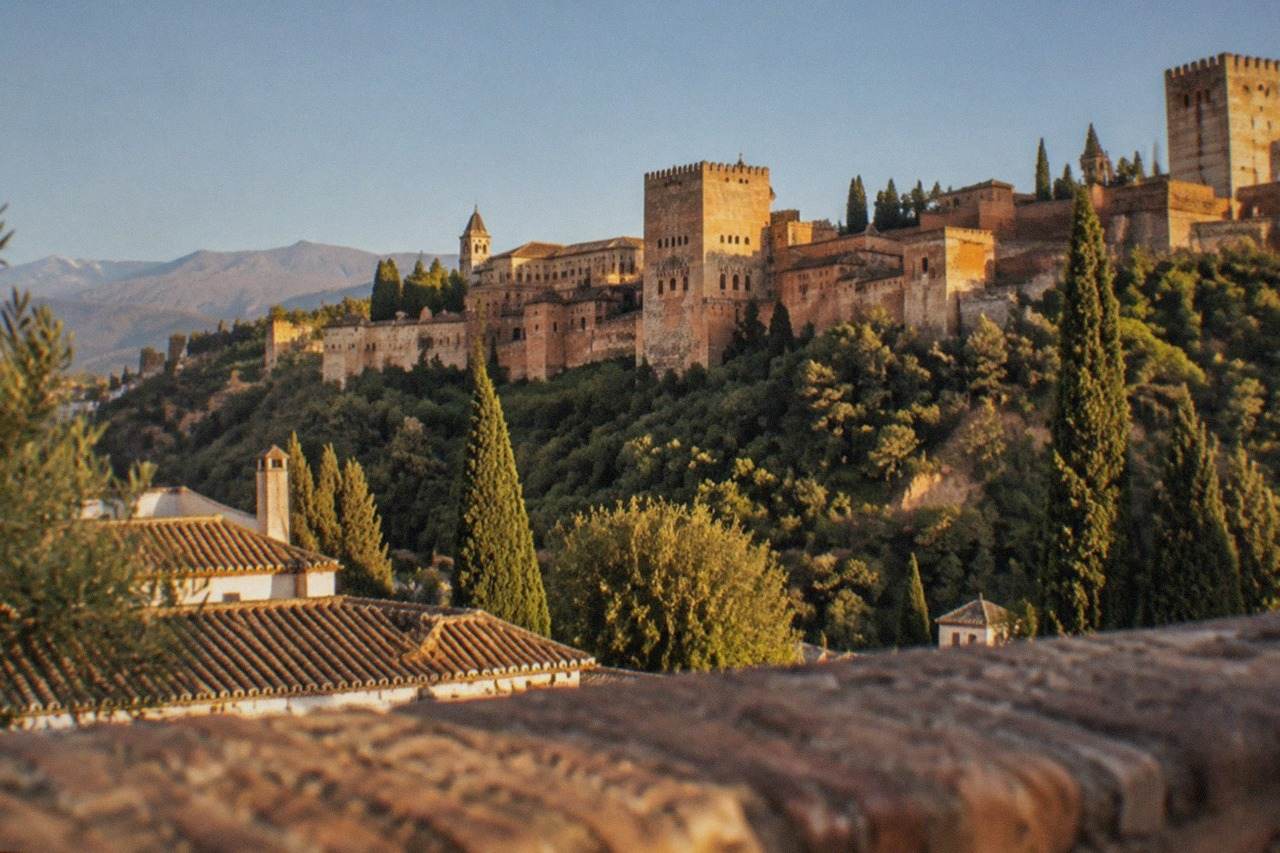The Alhambra palace complex seen from a hillside viewpoint across the city of Granada
