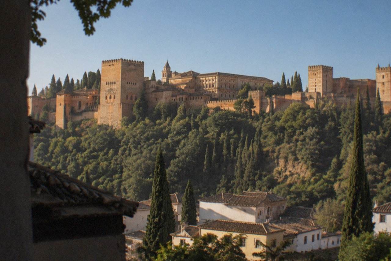 The Alhambra palace complex seen from a hillside viewpoint across the city of Granada