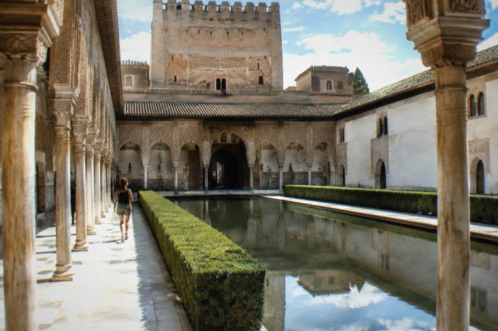 The ornate arches and carved stucco walls of a Nasrid palace courtyard