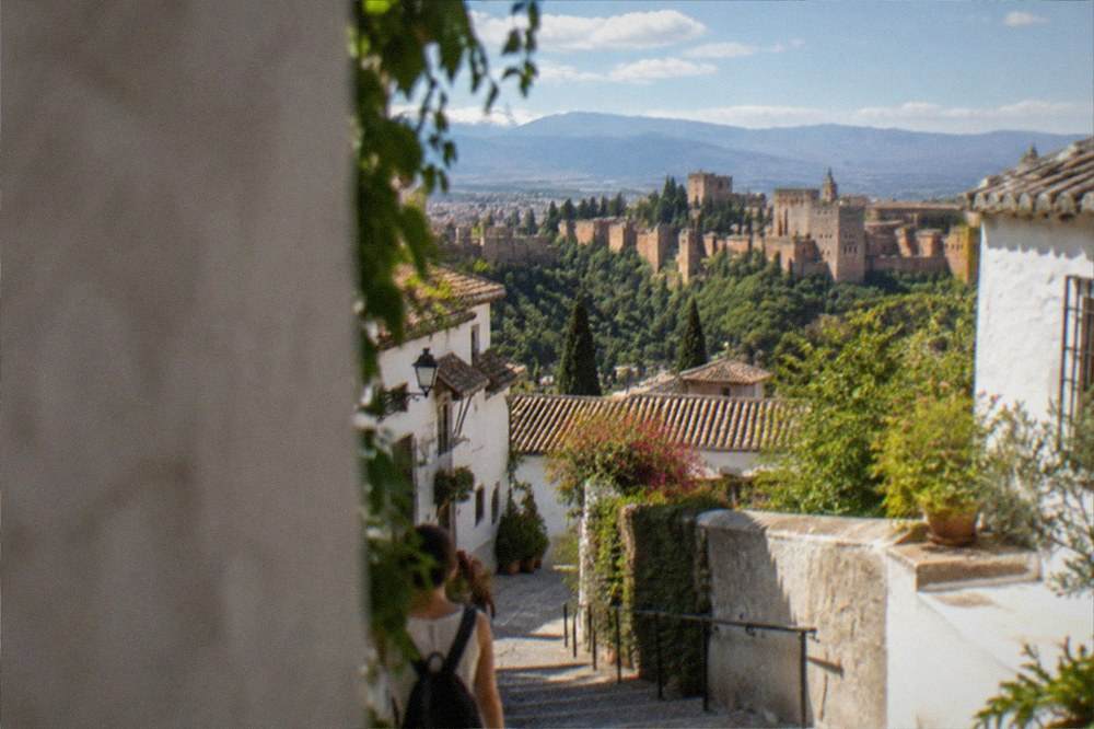 A white hillside neighbourhood of narrow cobbled lanes overlooking the city of Granada