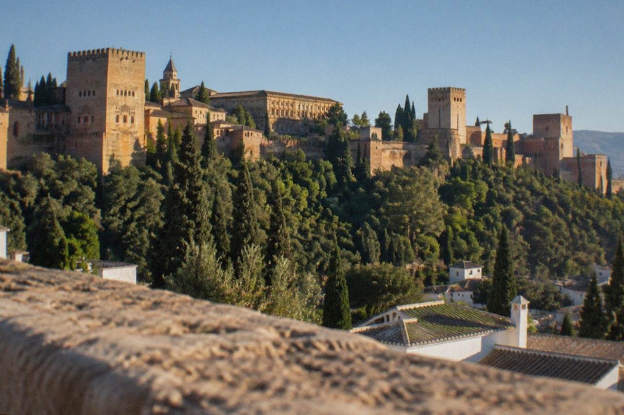 The Alhambra palace complex seen from a hillside viewpoint across the city of Granada