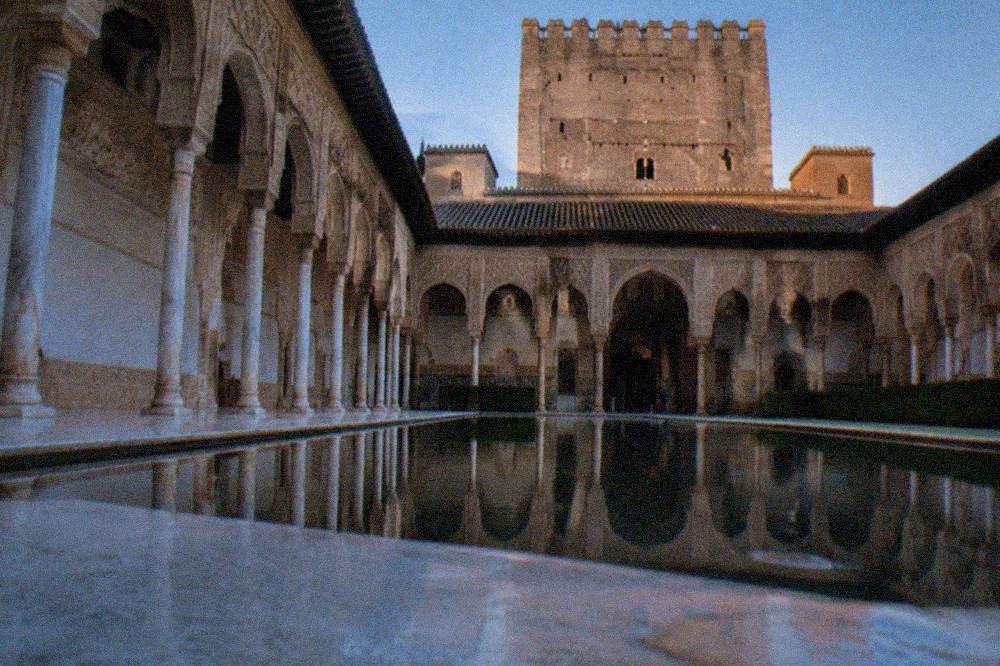 Carved stucco walls and arched windows inside the Nasrid Palaces at the Alhambra