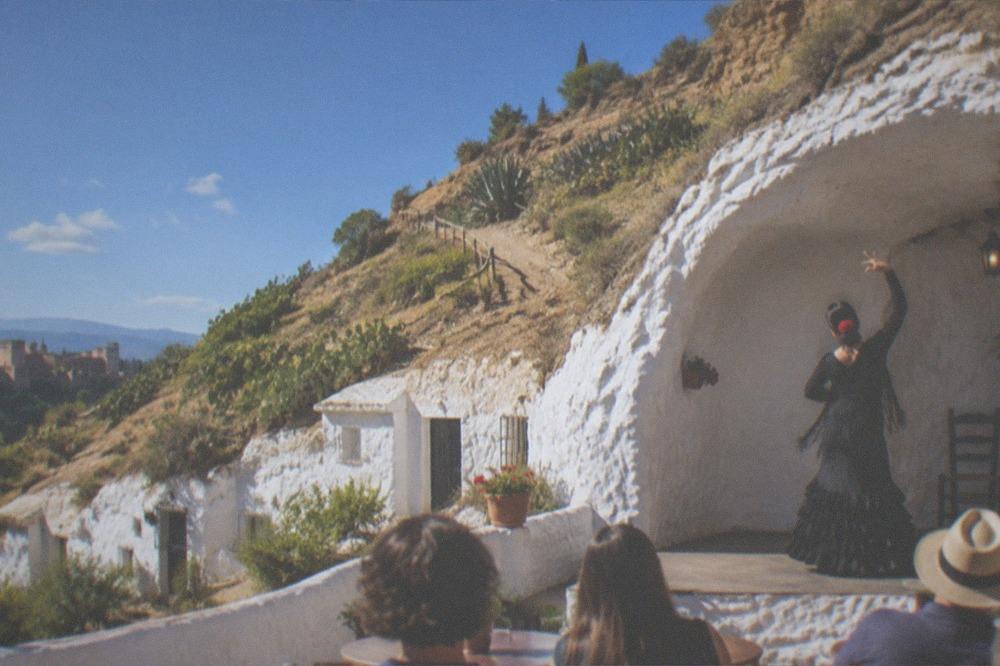 A flamenco dancer performing inside a whitewashed cave venue in Sacromonte