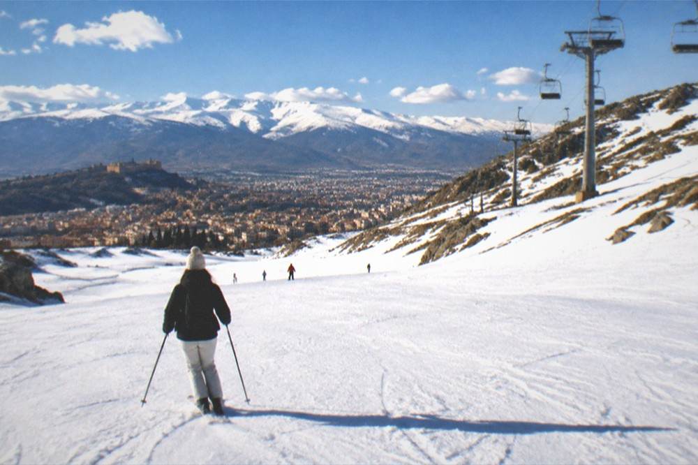 The Sierra Nevada mountains with snow rising behind the rooftops of Granada