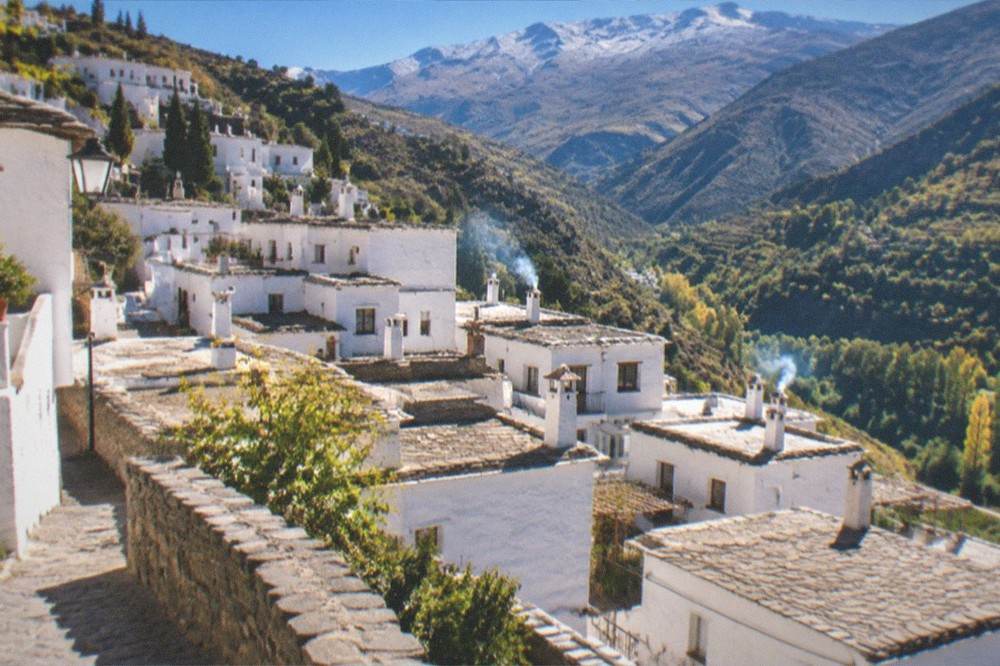 White mountain villages of the Alpujarras terraced on a hillside above green valleys